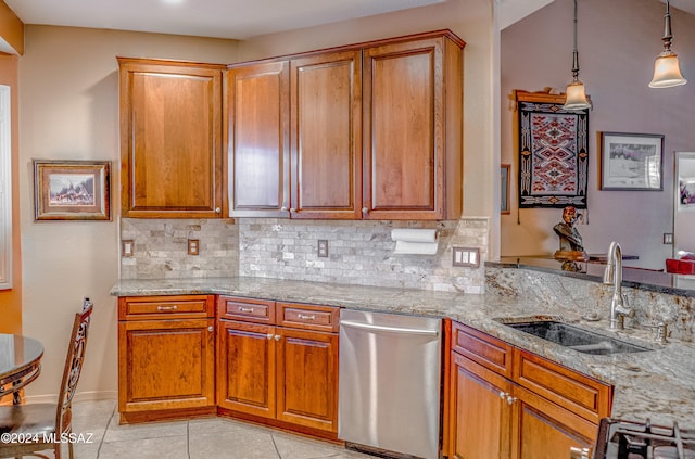 kitchen featuring light stone counters, sink, light tile patterned floors, decorative light fixtures, and dishwasher