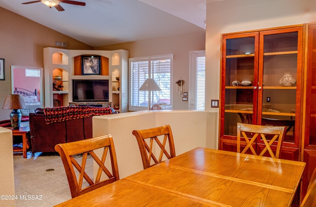 dining space with light tile patterned floors, vaulted ceiling, and ceiling fan