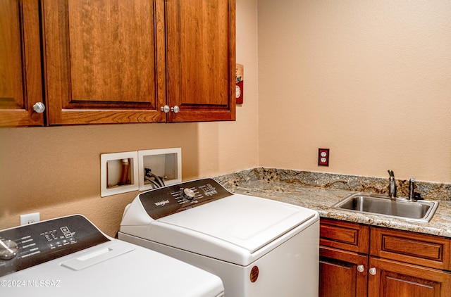 clothes washing area featuring cabinets, separate washer and dryer, and sink