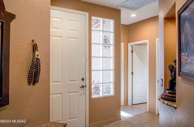 doorway to outside with light tile patterned floors