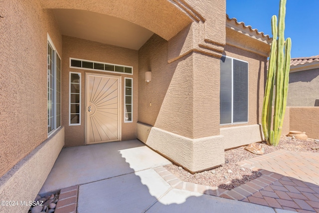 view of exterior entry featuring a patio area