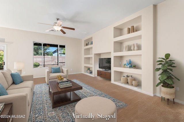 carpeted living room featuring ceiling fan and built in features