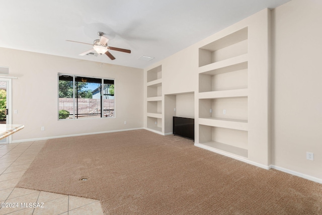 unfurnished living room with ceiling fan, built in features, and light tile patterned floors