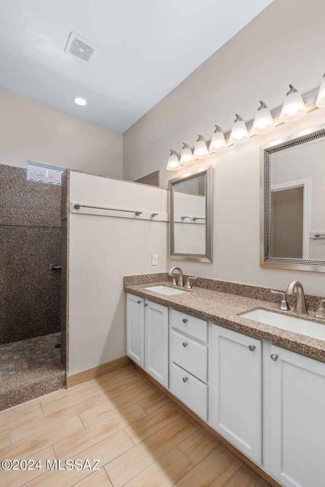 bathroom with vanity and tiled shower