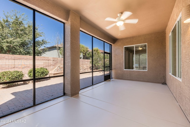 unfurnished sunroom featuring ceiling fan