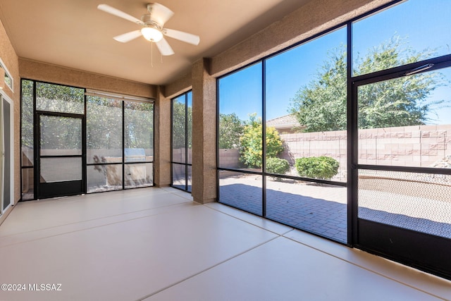 unfurnished sunroom featuring plenty of natural light and ceiling fan