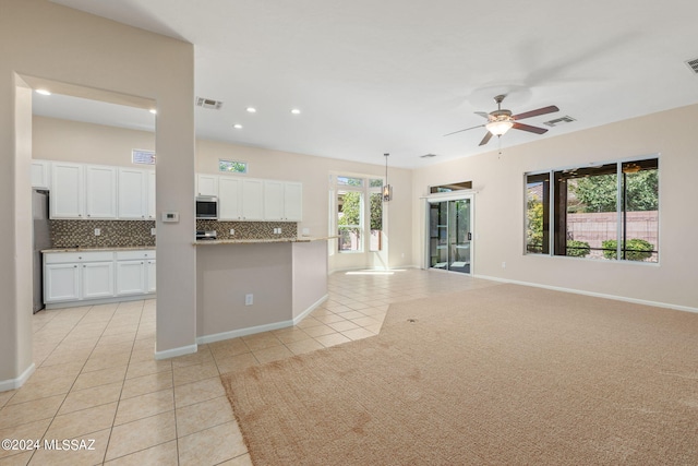 interior space with backsplash, stainless steel appliances, ceiling fan, light tile patterned floors, and white cabinetry