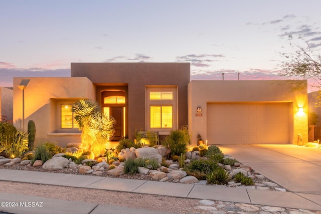 southwest-style home featuring an attached garage and concrete driveway