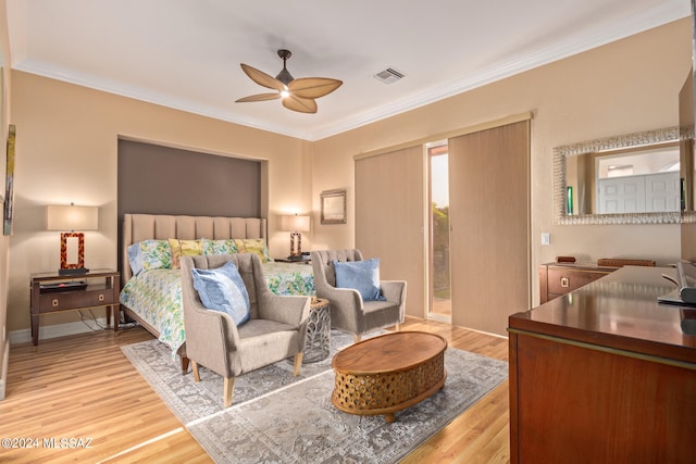 bedroom with ceiling fan, crown molding, and light hardwood / wood-style floors