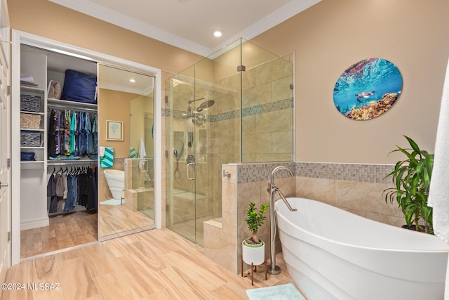 bathroom featuring ornamental molding, hardwood / wood-style flooring, and independent shower and bath