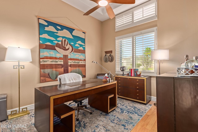 home office with wood finished floors, ceiling fan, and baseboards