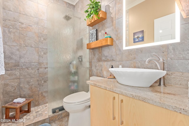 full bathroom featuring toilet, tile walls, crown molding, a walk in shower, and vanity