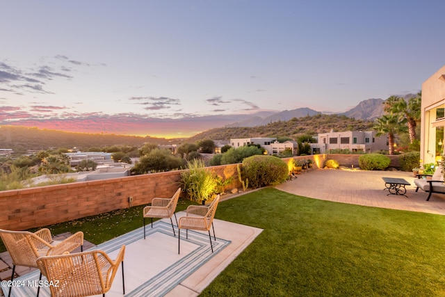 yard at dusk with a mountain view and a patio area