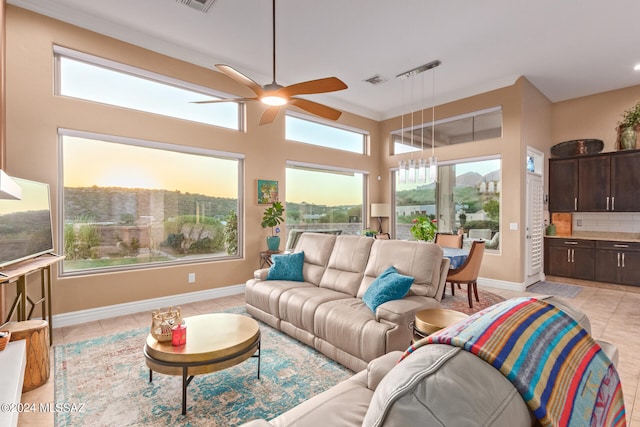 living room with ceiling fan, light tile patterned flooring, and ornamental molding