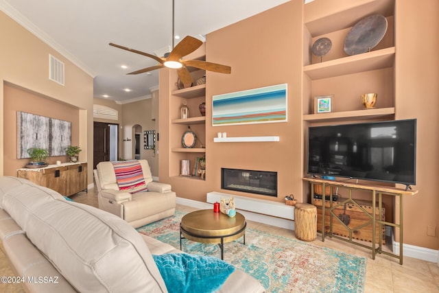 tiled living room featuring built in shelves, baseboards, a ceiling fan, crown molding, and recessed lighting