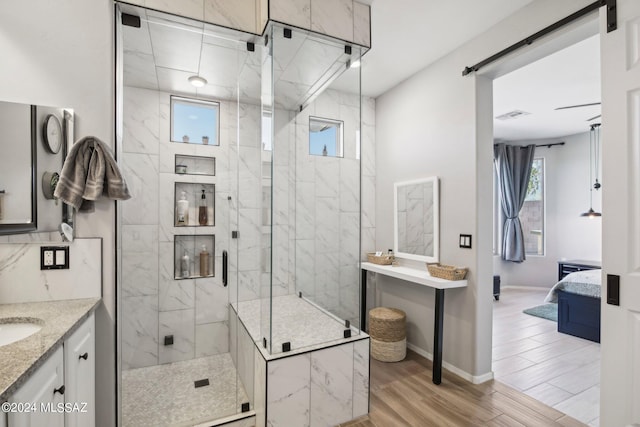 bathroom with a shower with door, vanity, and wood-type flooring