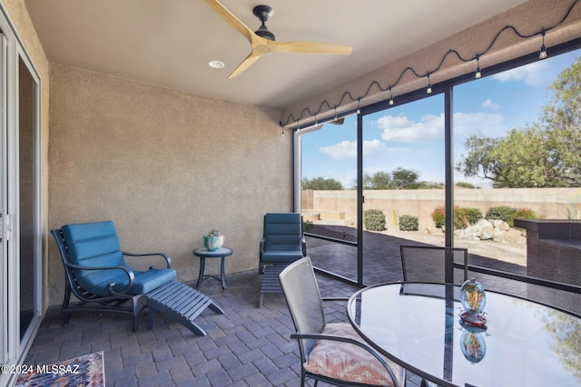 sunroom / solarium featuring ceiling fan