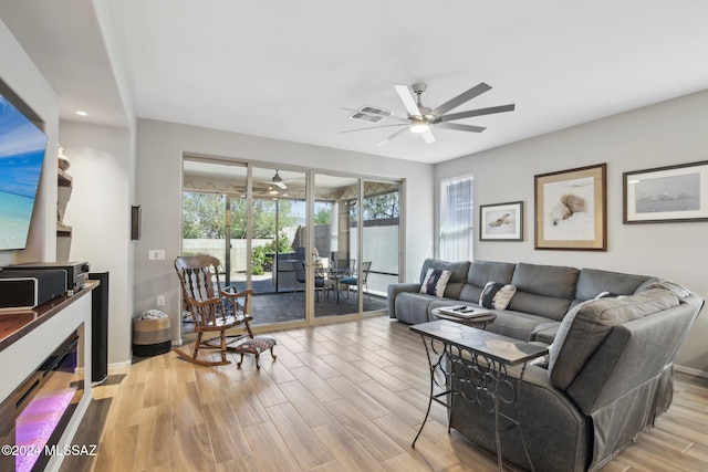 living room with light hardwood / wood-style flooring and ceiling fan