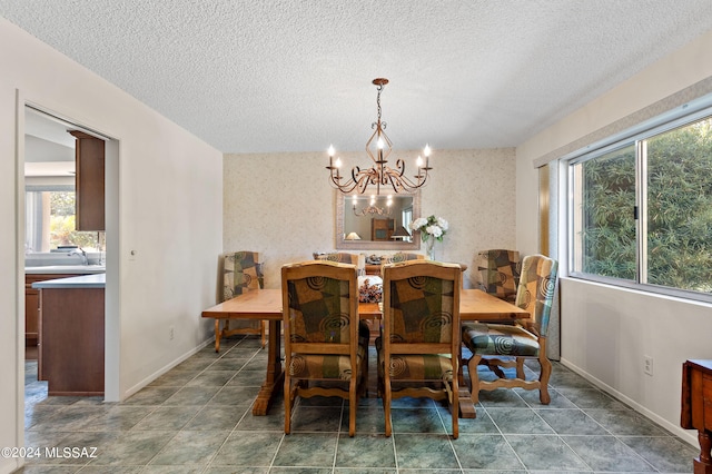 dining space with a textured ceiling and an inviting chandelier