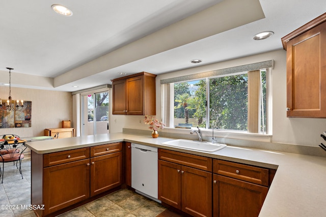 kitchen featuring pendant lighting, dishwasher, sink, a wealth of natural light, and kitchen peninsula