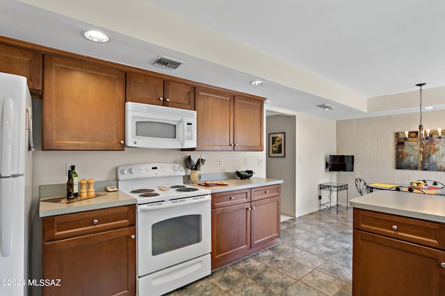 kitchen featuring decorative light fixtures, white appliances, and an inviting chandelier