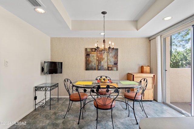 dining area with a tray ceiling and an inviting chandelier