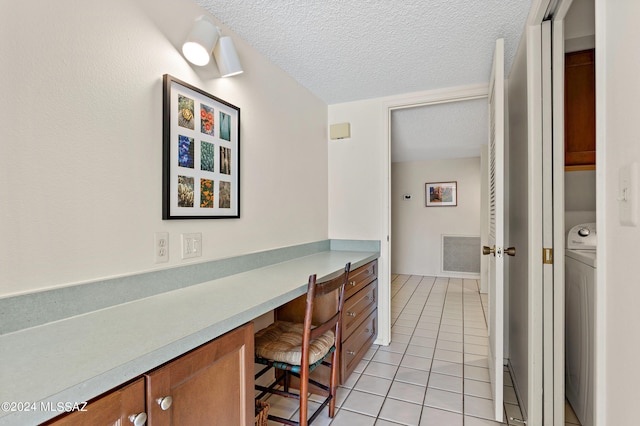 bathroom with a textured ceiling, washer / clothes dryer, and tile patterned floors