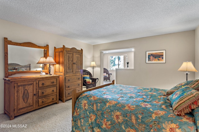 bedroom with light colored carpet and a textured ceiling