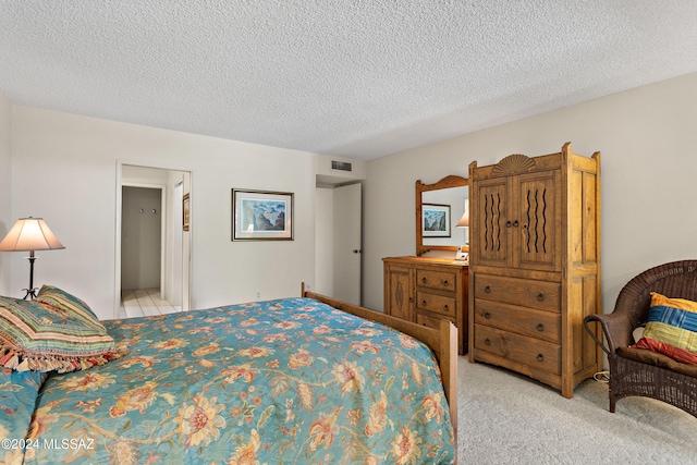 bedroom featuring light colored carpet and a textured ceiling