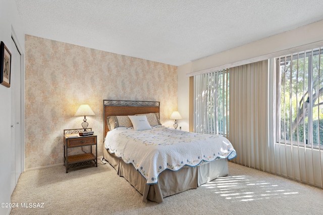 bedroom featuring light carpet and a textured ceiling