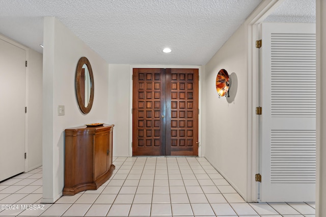 tiled entryway with a textured ceiling