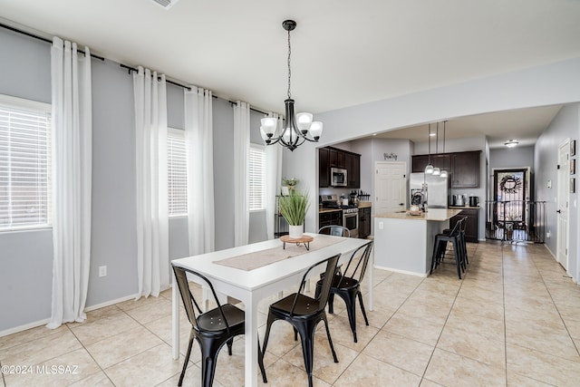 dining space with light tile patterned floors and a chandelier