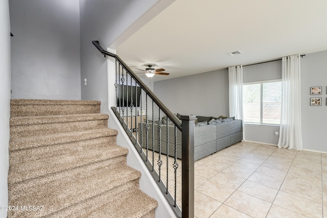 stairway with ceiling fan and tile patterned floors