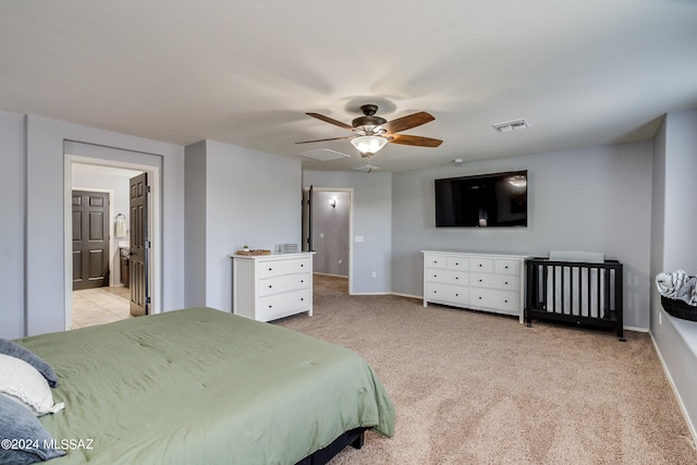 bedroom featuring light carpet, connected bathroom, and ceiling fan