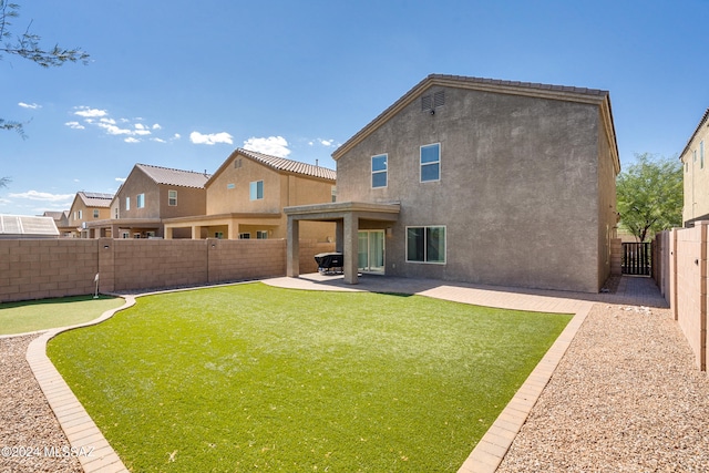 back of property featuring a patio and a yard