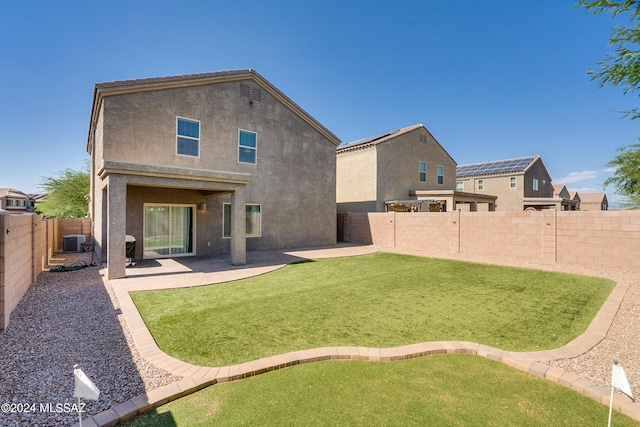 back of property featuring a yard, cooling unit, and a patio area