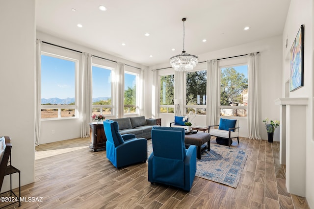 sunroom / solarium with a notable chandelier, a mountain view, and plenty of natural light