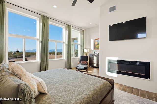 13123 E Molokai Ln, Vail, AZ 85641 - bedroom with visible vents, a glass covered fireplace, wood finished floors, recessed lighting, and a ceiling fan