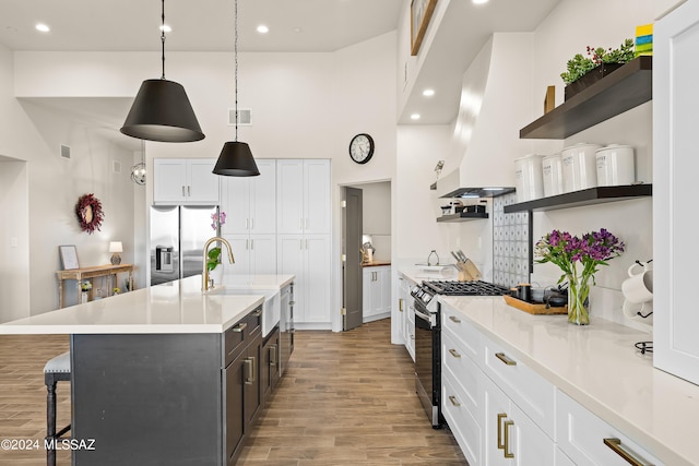 13123 E Molokai Ln, Vail, AZ 85641 - kitchen featuring a towering ceiling, open shelves, a sink, a breakfast bar, and stainless steel appliances