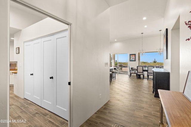 hall with a notable chandelier and hardwood / wood-style floors