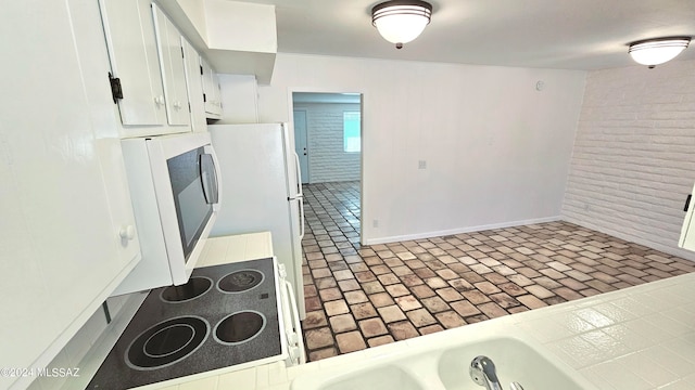 kitchen with white cabinetry, stovetop, and tile countertops