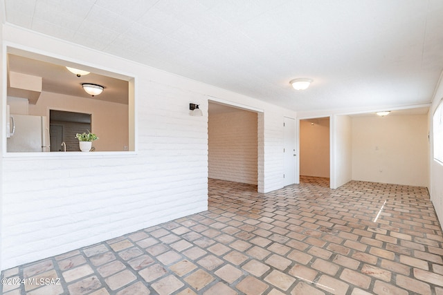 empty room featuring brick wall