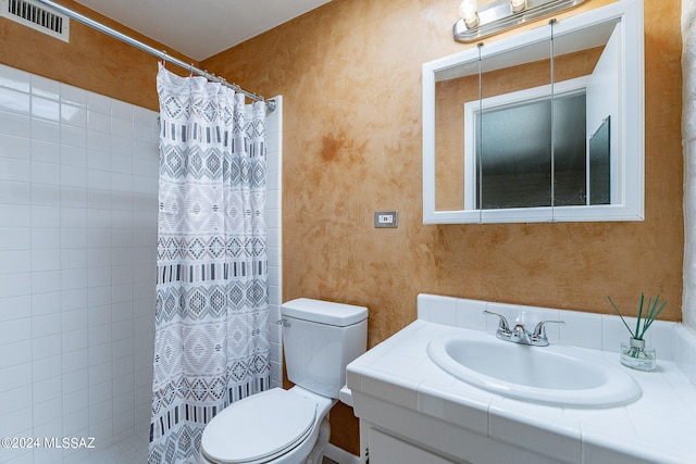 bathroom with curtained shower, vanity, and toilet