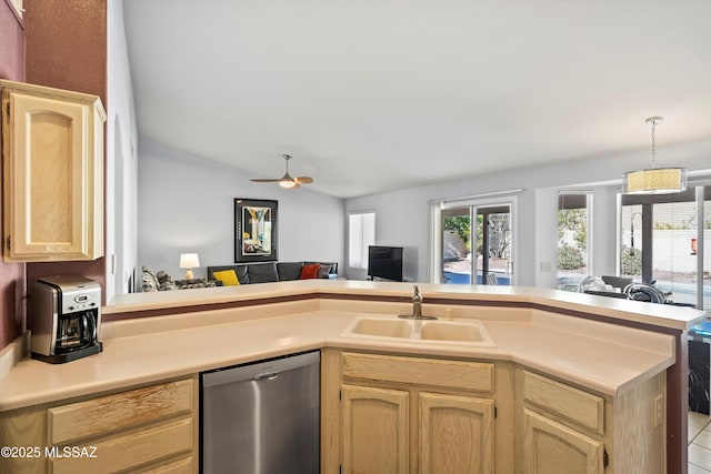 kitchen with kitchen peninsula, light brown cabinets, stainless steel dishwasher, sink, and lofted ceiling