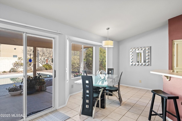 tiled dining space featuring lofted ceiling