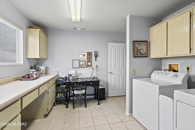 laundry area featuring washer and dryer, cabinets, and light tile patterned floors