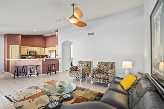 tiled living room featuring high vaulted ceiling and ceiling fan