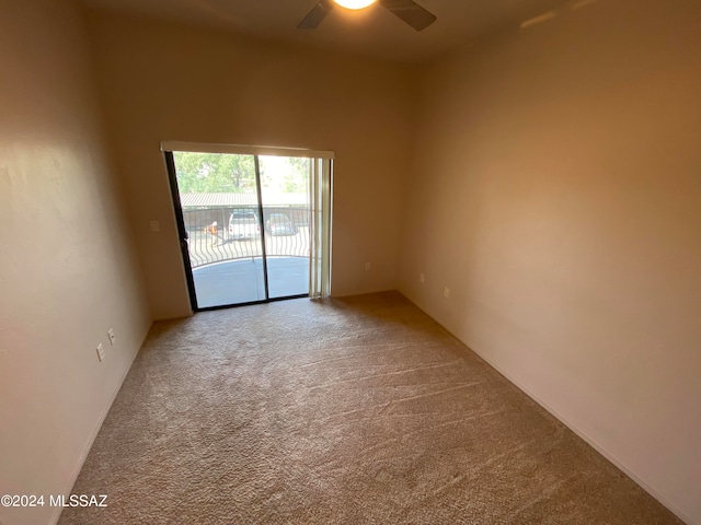 carpeted spare room featuring ceiling fan