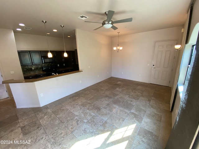 unfurnished living room with ceiling fan with notable chandelier