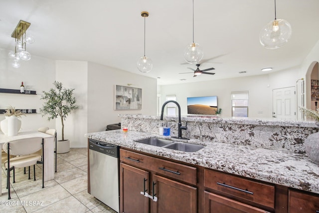 kitchen featuring sink, stainless steel dishwasher, ceiling fan, light stone countertops, and pendant lighting